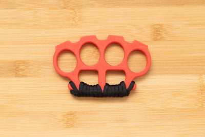 Red Brass Knuckles wrapped in Black Paracord