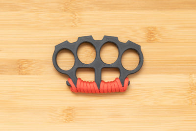 Black Brass Knuckles wrapped in Red Paracord