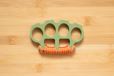 Military Green Brass Knuckles wrapped in Orange Paracord